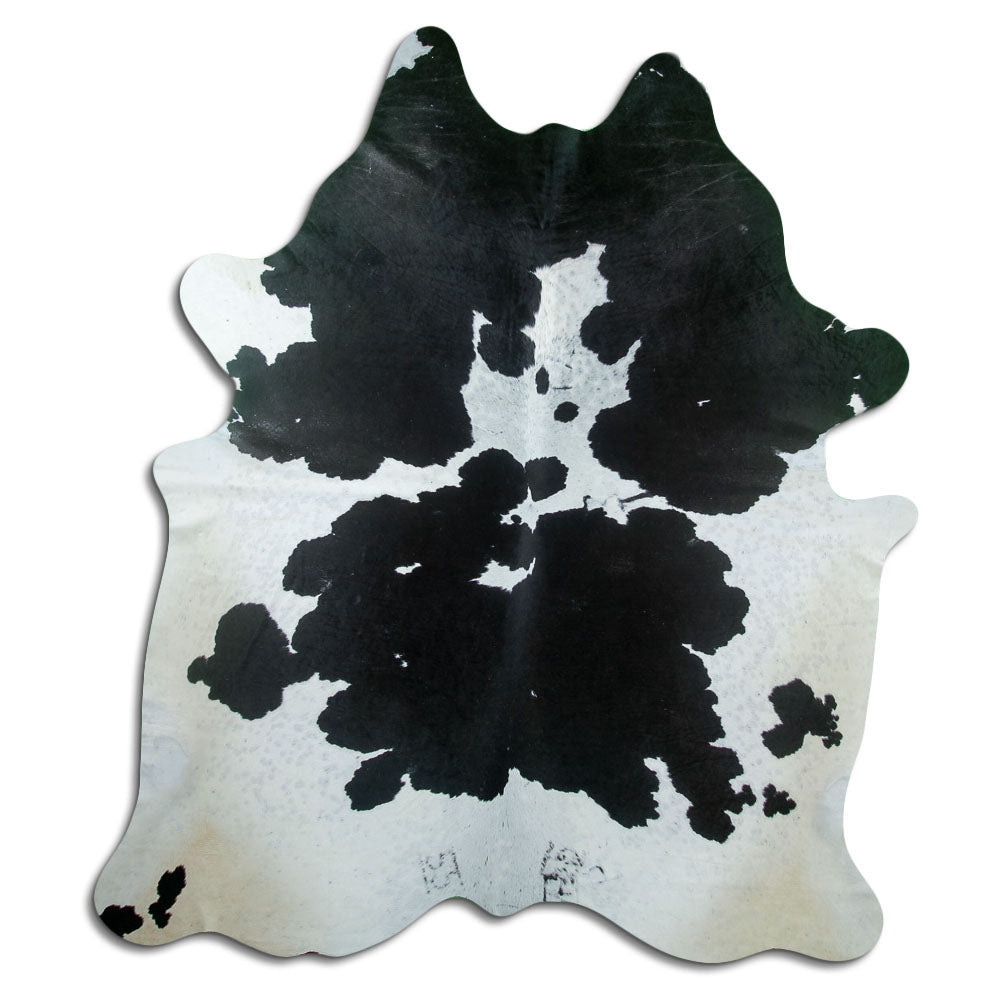 Black and white cowhide rug of about 230 × 190 cm, seen from above: the exact hide you receive