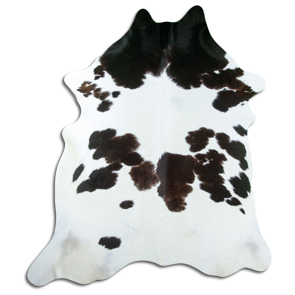 Black and white cowhide rug of about 230 × 190 cm, seen from above: the exact hide you receive