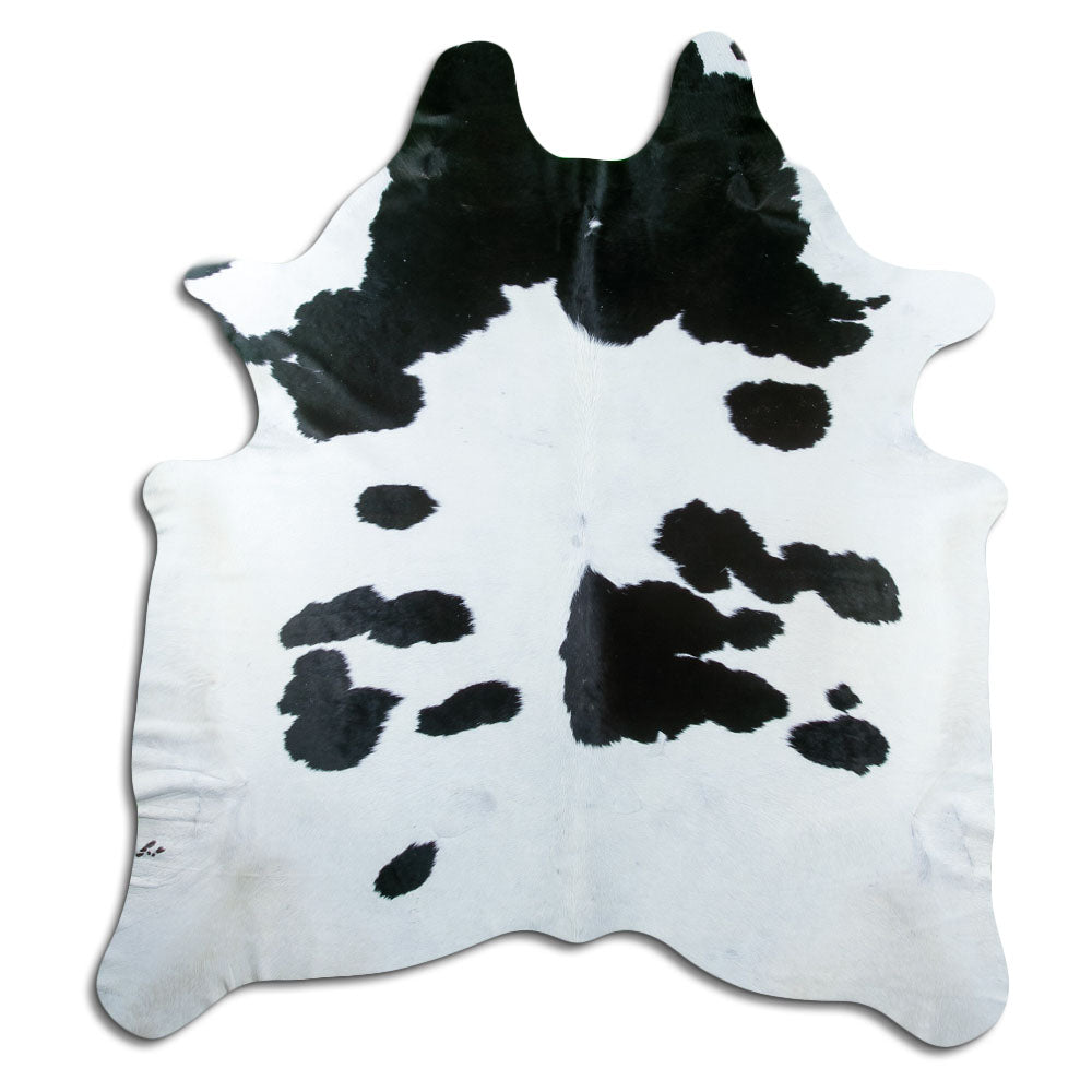 Black and white cowhide rug of about 220 × 200 cm, seen from above: the exact hide you receive
