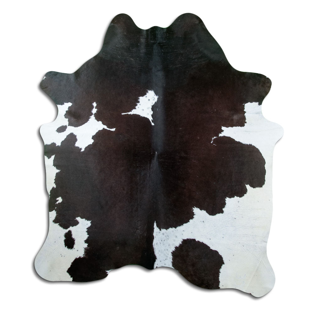 Black and white cowhide rug of about 200 × 180 cm, seen from above: the exact hide you receive