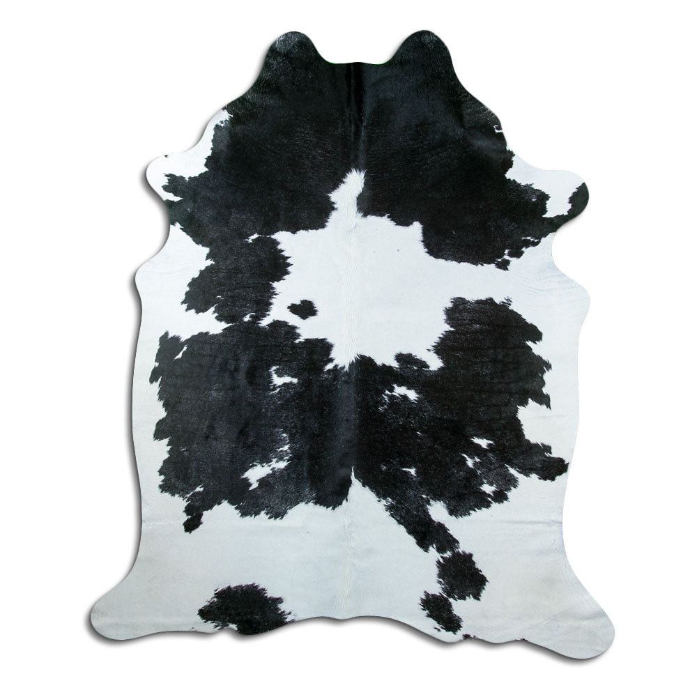 Black and white cowhide rug of about 220 × 190 cm, seen from above: the exact hide you receive