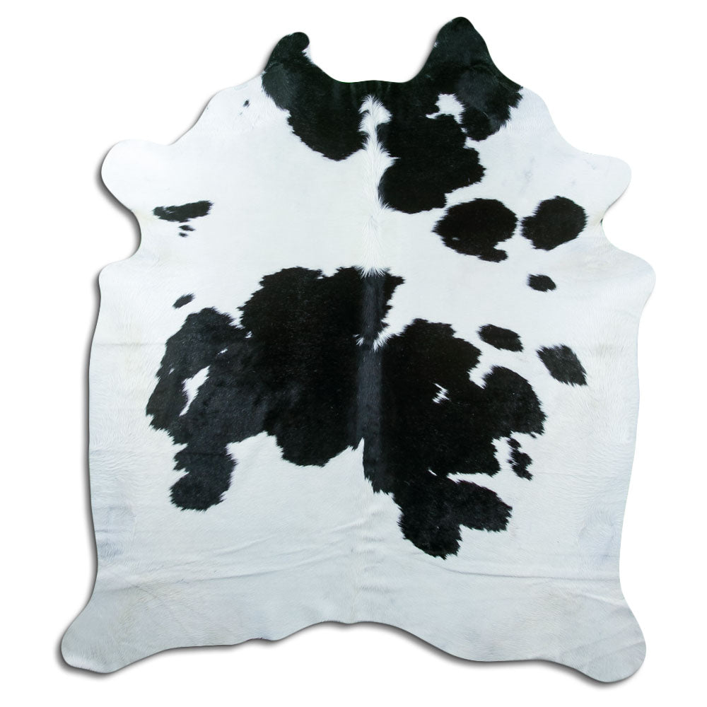 Black and white cowhide rug of about 210 × 190 cm, seen from above: the exact hide you receive