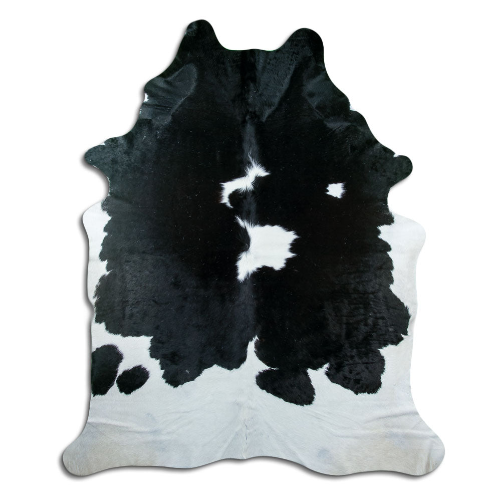 Black and white cowhide rug of about 230 × 190 cm, seen from above: the exact hide you receive