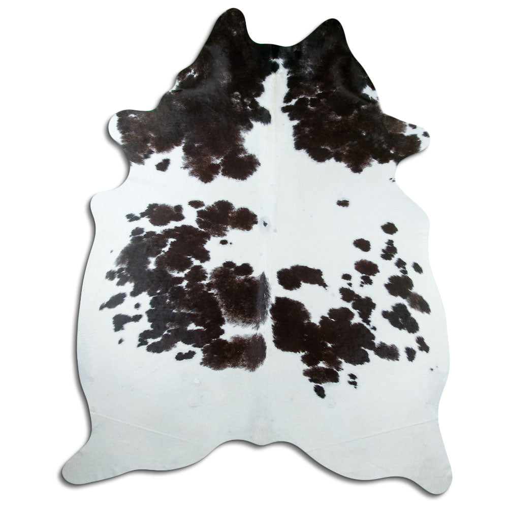 Black and white cowhide rug of about 240 × 200 cm, seen from above: the exact hide you receive