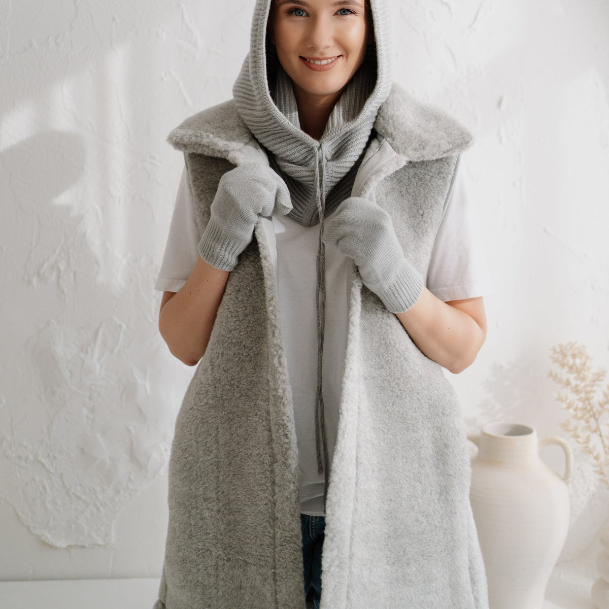 The grey Wave merino vest with the hood up
