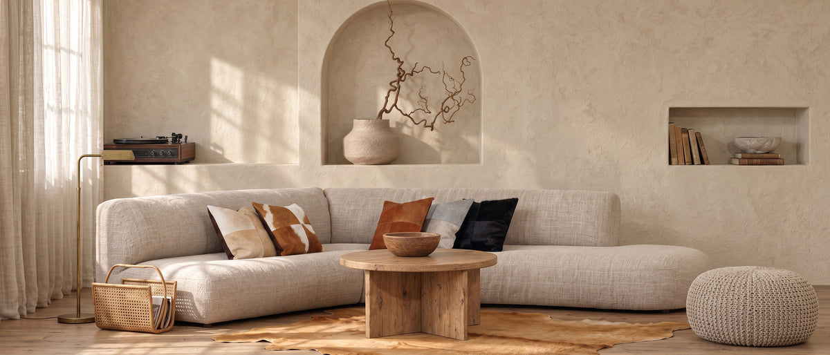 Brown cowhide rug in front of a curved sofa