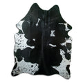 Black and white cowhide rug of about 190 × 150 cm, seen from above: the exact hide you receive