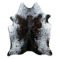Black and white cowhide rug of about 180 × 150 cm, seen from above: the exact hide you receive