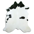 Black and white cowhide rug of about 180 × 170 cm, seen from above: the exact hide you receive