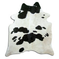 Black and white cowhide rug of about 180 × 160 cm, seen from above: the exact hide you receive