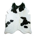 Black and white cowhide rug of about 180 × 150 cm, seen from above: the exact hide you receive