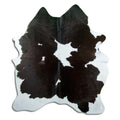 Black and white cowhide rug of about 180 × 150 cm, seen from above: the exact hide you receive