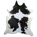 Black and white cowhide rug of about 220 × 200 cm, seen from above: the exact hide you receive