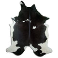 Black and white cowhide rug of about 250 × 220 cm, seen from above: the exact hide you receive