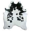 Black and white cowhide rug of about 210 × 180 cm, seen from above: the exact hide you receive
