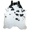Black and white cowhide rug of about 230 × 190 cm, seen from above: the exact hide you receive