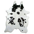 Black and white cowhide rug of about 230 × 170 cm, seen from above: the exact hide you receive
