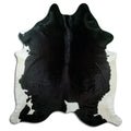 Black and white cowhide rug of about 230 × 210 cm, seen from above: the exact hide you receive