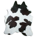Black and white cowhide rug of about 210 × 180 cm, seen from above: the exact hide you receive