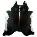 Black and white cowhide rug of about 220 × 200 cm, seen from above: the exact hide you receive
