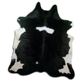 Black and white cowhide rug of about 220 × 200 cm, seen from above: the exact hide you receive