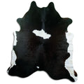 Black and white cowhide rug of about 210 × 180 cm, seen from above: the exact hide you receive