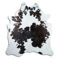 Black and white cowhide rug of about 220 × 200 cm, seen from above: the exact hide you receive