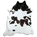 Black and white cowhide rug of about 230 × 190 cm, seen from above: the exact hide you receive