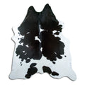 Black and white cowhide rug of about 230 × 200 cm, seen from above: the exact hide you receive