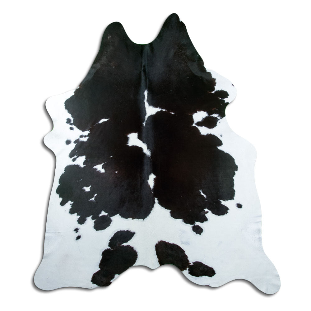 Black and white cowhide rug of about 230 × 200 cm, seen from above: the exact hide you receive