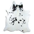 Black and white cowhide rug of about 220 × 190 cm, seen from above: the exact hide you receive