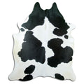 Black and white cowhide rug of about 220 × 190 cm, seen from above: the exact hide you receive