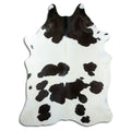 Black and white cowhide rug of about 240 × 180 cm, seen from above: the exact hide you receive