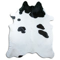 Black and white cowhide rug of about 220 × 190 cm, seen from above: the exact hide you receive