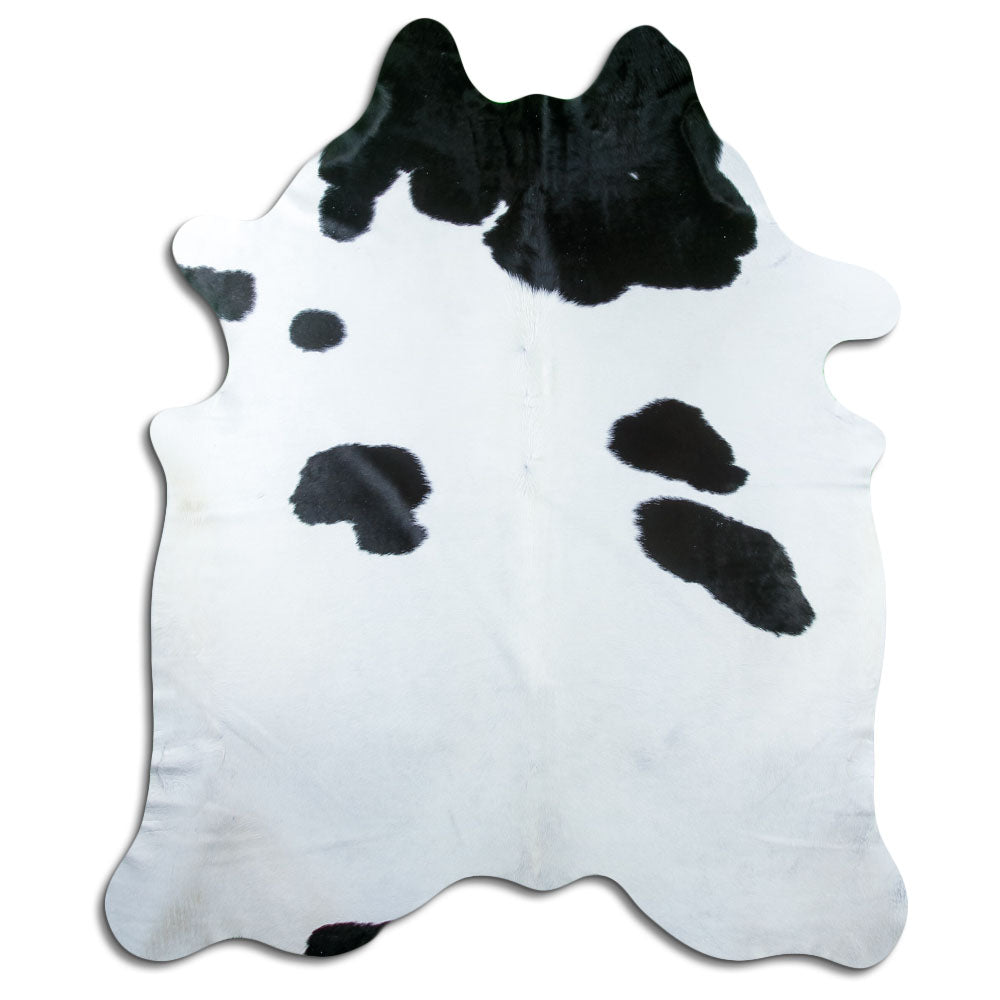 Black and white cowhide rug of about 220 × 190 cm, seen from above: the exact hide you receive