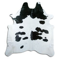 Black and white cowhide rug of about 220 × 200 cm, seen from above: the exact hide you receive