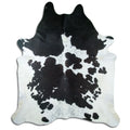 Black and white cowhide rug of about 240 × 210 cm, seen from above: the exact hide you receive
