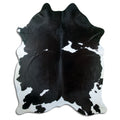 Black and white cowhide rug of about 230 × 180 cm, seen from above: the exact hide you receive