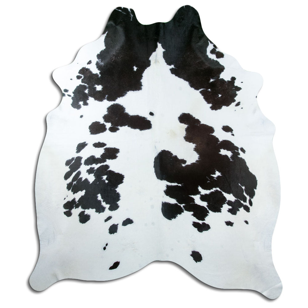 Black and white cowhide rug of about 230 × 200 cm, seen from above: the exact hide you receive