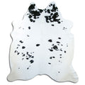 Black and white cowhide rug of about 220 × 190 cm, seen from above: the exact hide you receive