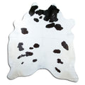 Black and white cowhide rug of about 220 × 210 cm, seen from above: the exact hide you receive