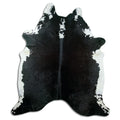 Black and white cowhide rug of about 220 × 190 cm, seen from above: the exact hide you receive