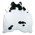 Black and white cowhide rug of about 200 × 180 cm, seen from above: the exact hide you receive