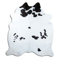 Black and white cowhide rug of about 240 × 210 cm, seen from above: the exact hide you receive