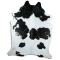 Black and white cowhide rug of about 240 × 190 cm, seen from above: the exact hide you receive