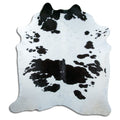 Black and white cowhide rug of about 220 × 210 cm, seen from above: the exact hide you receive