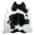 Black and white cowhide rug of about 220 × 200 cm, seen from above: the exact hide you receive