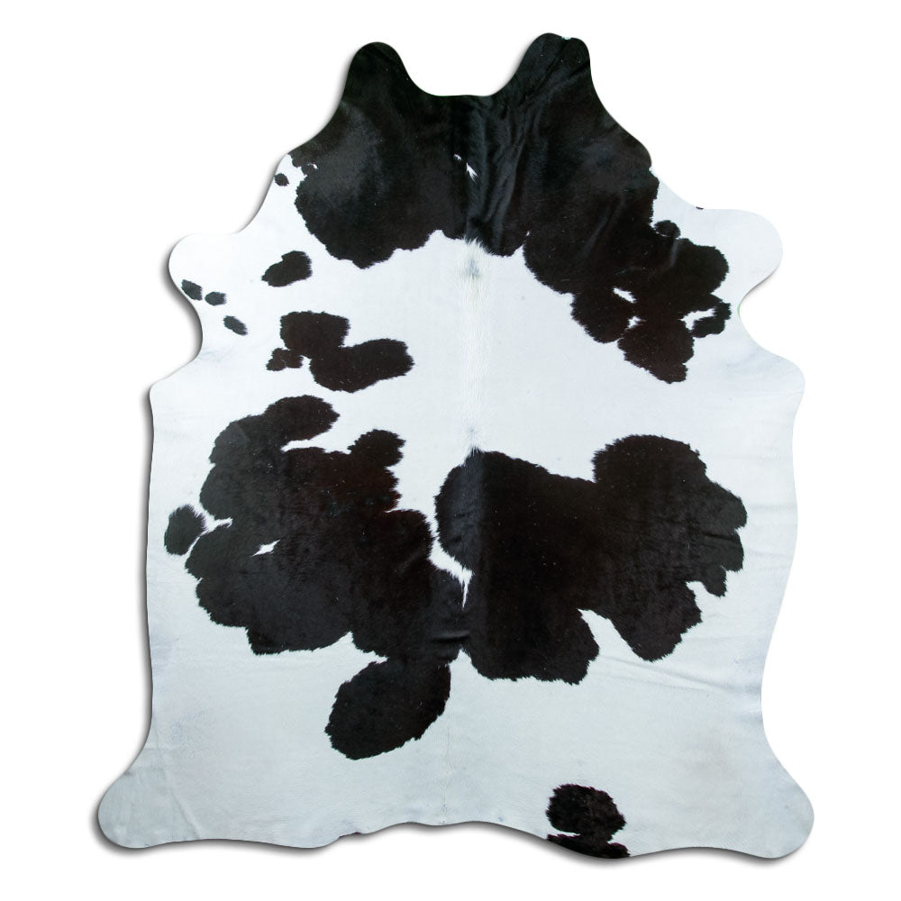 Black and white cowhide rug of about 230 × 200 cm, seen from above: the exact hide you receive