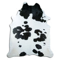 Black and white cowhide rug of about 240 × 200 cm, seen from above: the exact hide you receive