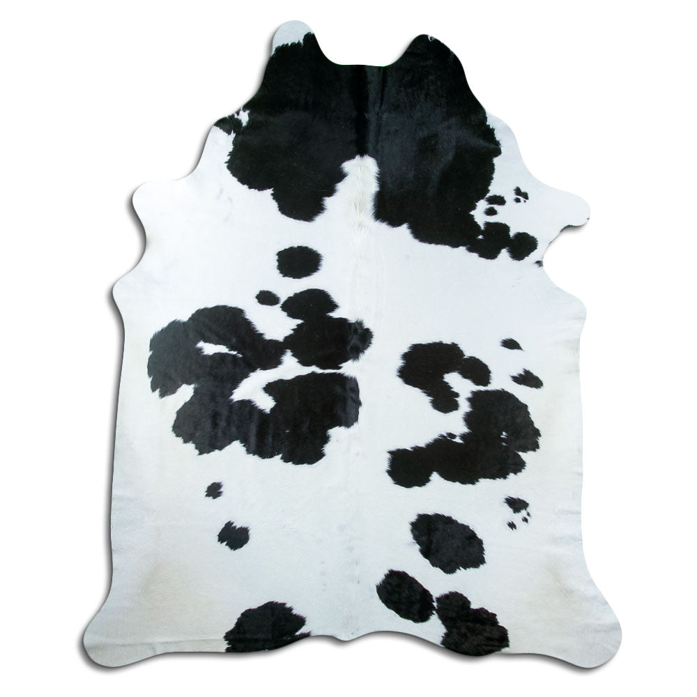 Black and white cowhide rug of about 240 × 200 cm, seen from above: the exact hide you receive